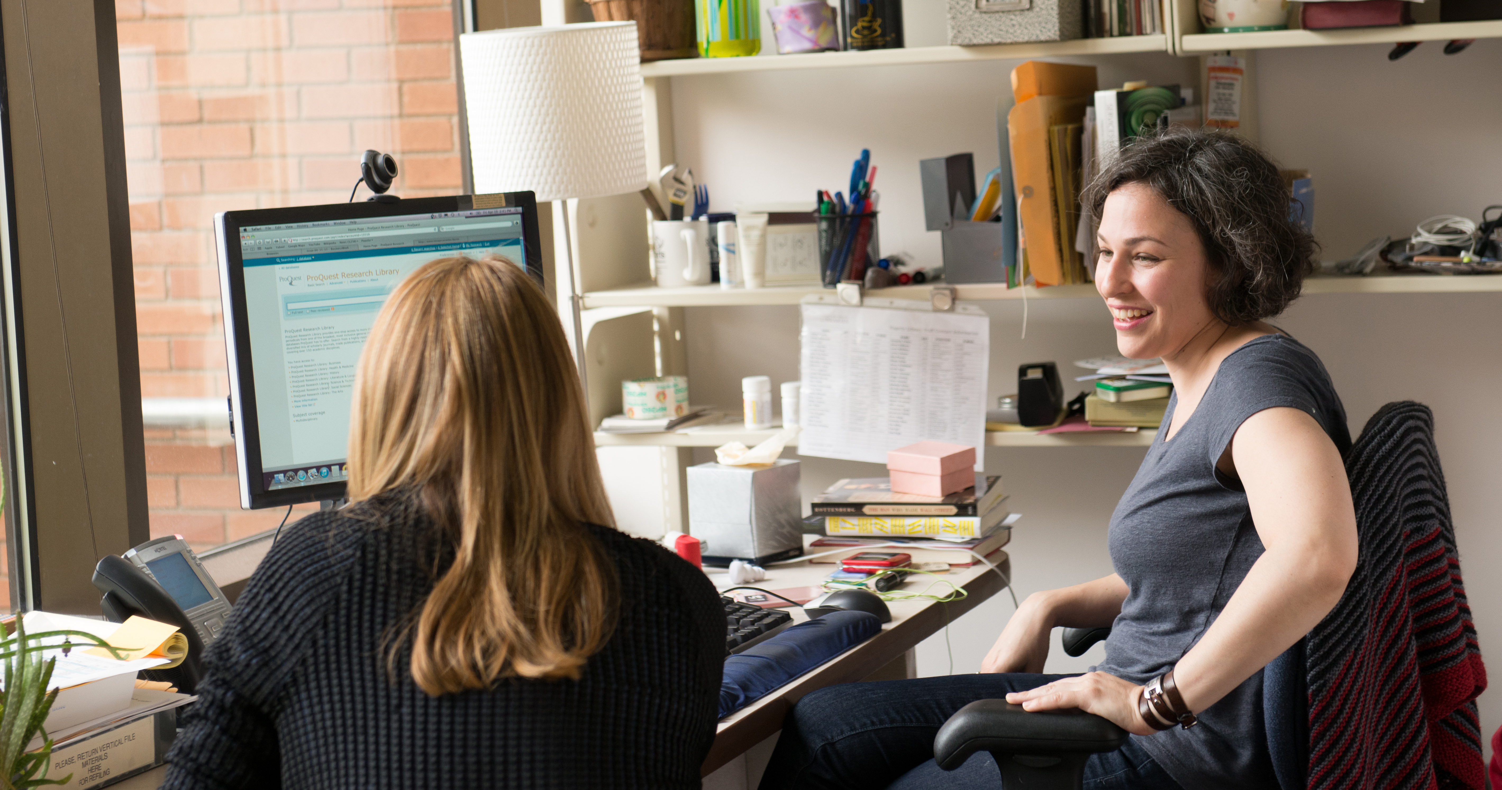 A librarian and a student sit and talk in an office in the W. W. Hagerty Library